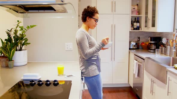 Woman having breakfast in kitchen 4k