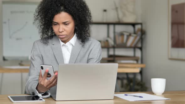 African Businesswoman Using Phone at Work