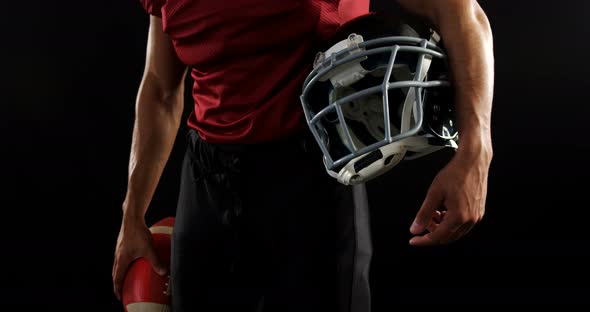 American football player holding a ball and head gear 4k