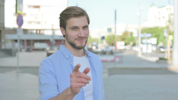 Man Pointing at the Camera and Inviting Outdoor
