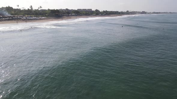 Aerial view of Canggu beach with surf people in afternoon