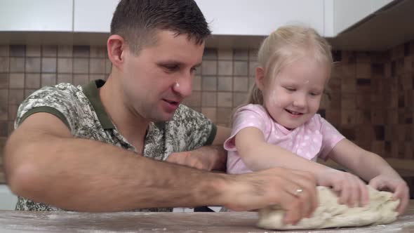 Father and Child with Daughter in the Kitchen Roll Out the Dough and Prepare Homemade Cakes