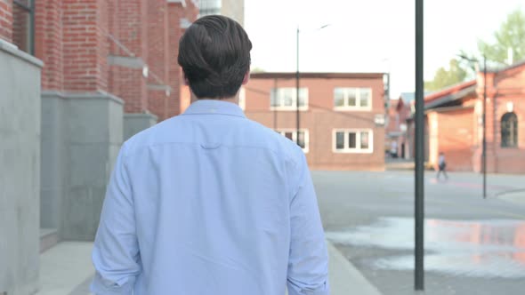 Back View of Man Walking in Empty Street