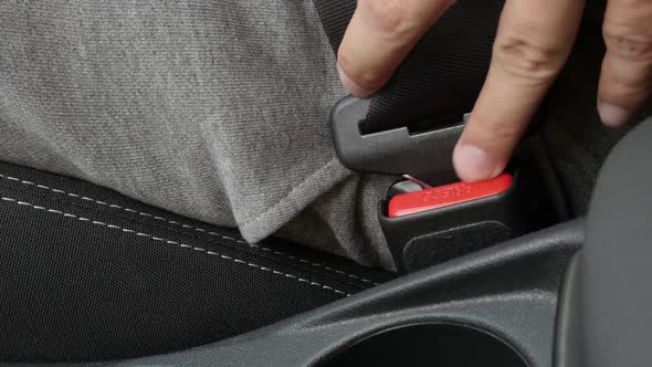 Disconnecting passenger 3-point seat  belt on car buckle slow-mo footage