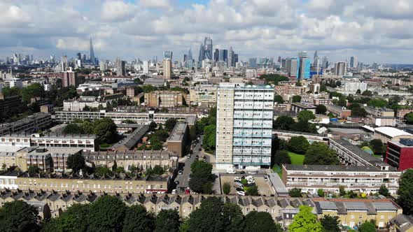 Reverse aerial shot of residential estates in Shadwell with London skyline in the background