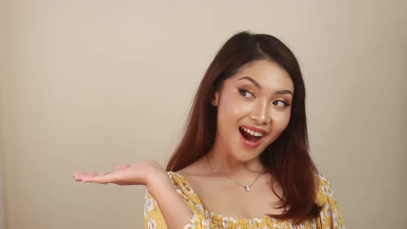 Happy and smile face with smile of young Asian girl with hand point on empty space.