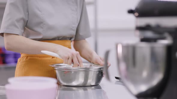 A Bright Girl Cooks Sweet Dishes at a Small Production Facility