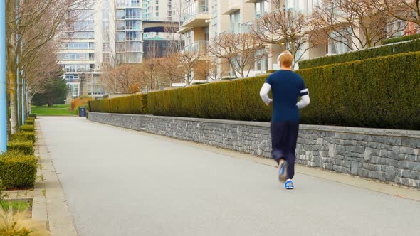 Man jogging on the sidewalk in the city 