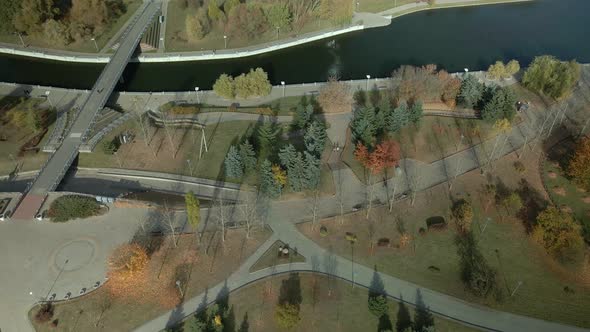 Walkways in the park area. Trees with yellow autumn leaves are visible.