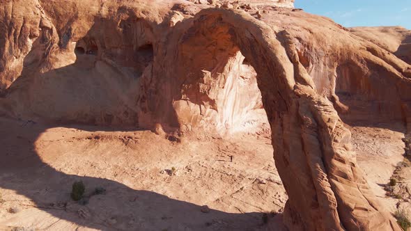 Aerial of a hiker under the Corona Arch near Moab, Utah