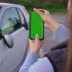 Girl with Mobile Green Screen Takes Photo in Parking - VideoHive Item for Sale