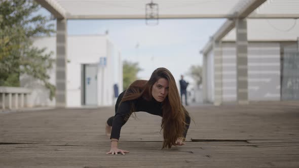 Young Darkhaired Woman Outdoors Looks Crazy and Crawls Toward Camera