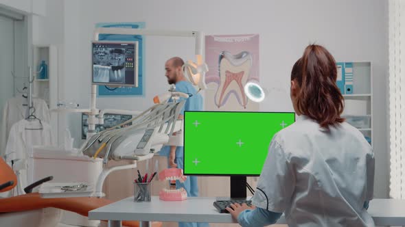 Dentist Using Computer with Horizontal Green Screen on Display