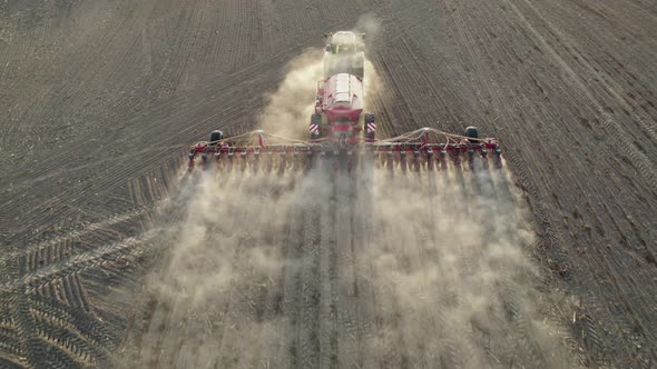 Agricultural tractor with special trailed equipment works the land before sowing crops.