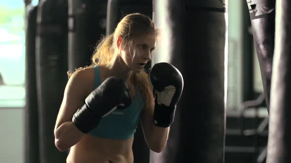 Woman does Muay Thai kickboxing training at the gym.