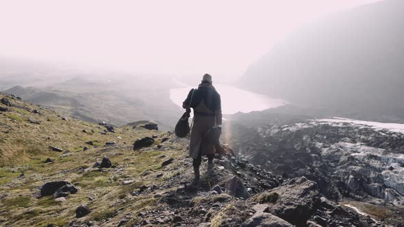 Man Walking Along Ridge To Looking Into Sunlit Valley