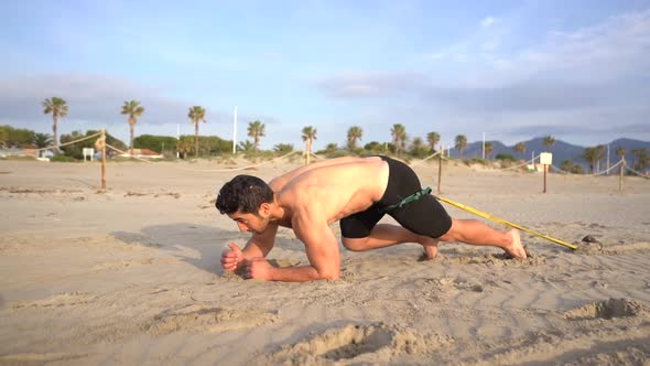 endurance activity dragging a kettlebell attached to a rubber band crawling on the sand