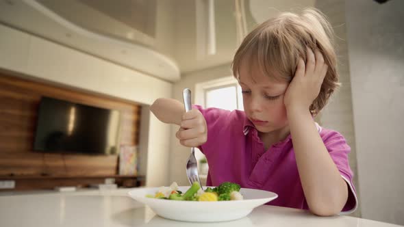 Boy Tries To Eat a Vegetables but Dosen't Like It and Rejects the Food. Healthy Food Concept