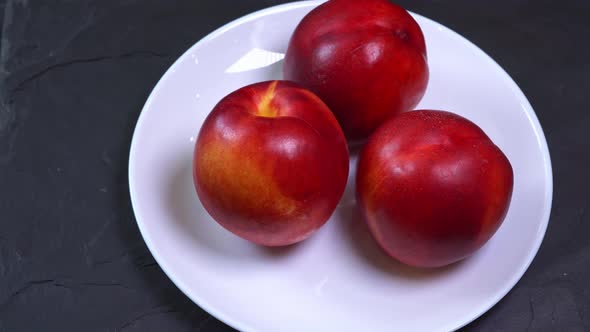 Spin Three Fresh Ripe Red and Yellow Peaches on a Plate