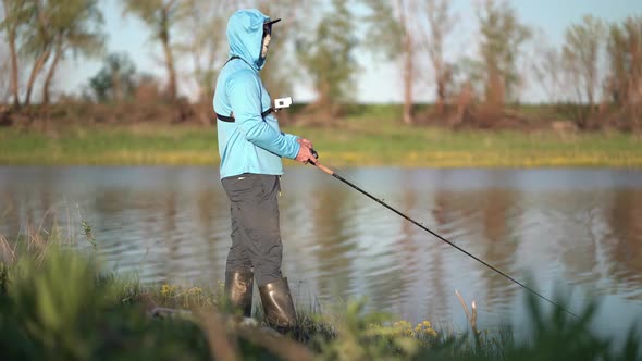 The Fisherman Sportsman Catches a Predatory Fish on a Spinning on the Lake