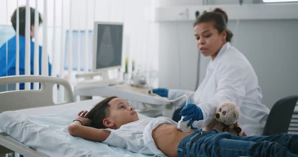 Doctor Examining Little Patient Belly with Ultrasound at Hospital