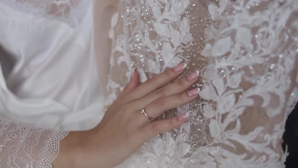 Bride in White Silk Boudoir Dress Touch Her Wedding Dress. Morning Preparations. Slow Motion