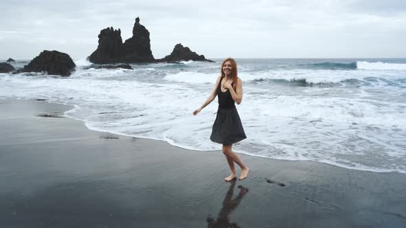 Young Woman in a Beautiful Dress Walks Along the Black Volcanic Black Sand Beach Benijo in the North