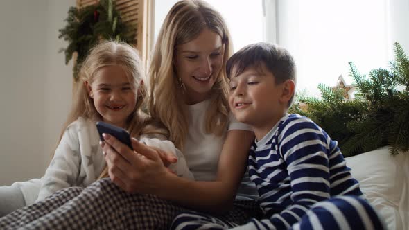 Mom and kids using smartphone at Christmas morning. Shot with RED helium camera in 8K