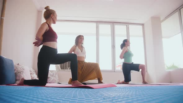 Three Women Standing on Yoga Mats on Their Knees and Does the Practice