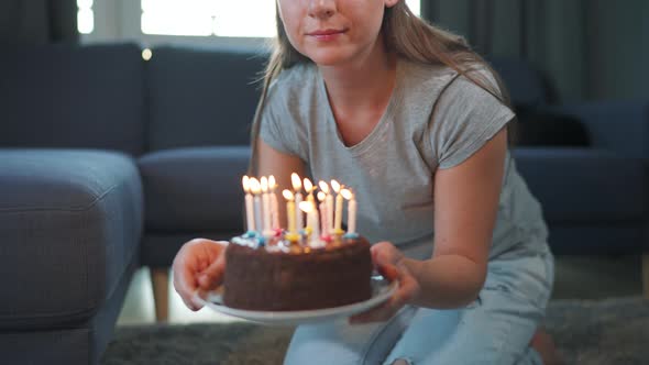 Woman Blowing Out Candles on Birthday Cake Celebrating Birthday at Home Alone