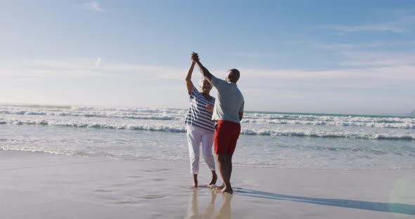 Senior african american couple dancing at the beach