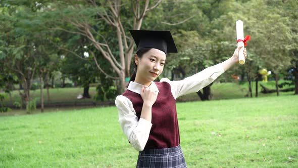 Young Attractive Asian Woman New Graduate in School Uniform Pose for Photos in the Park Outdoor