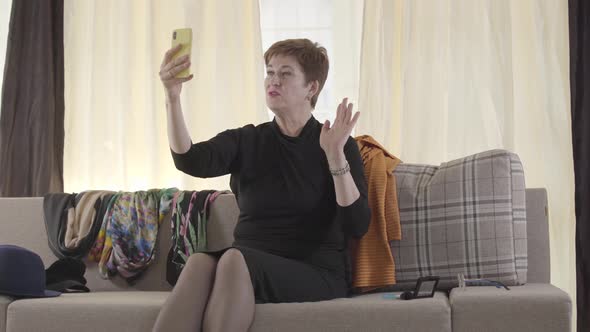Portrait of Beautiful Caucasian Senior Lady Recording Selfie Video on Her Smartphone. Mature Female