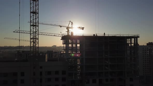 Construction Site at Sunset, Silhouette of a Construction Crane Near the Building