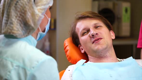 Dentist Talking to Man Patient After Examination