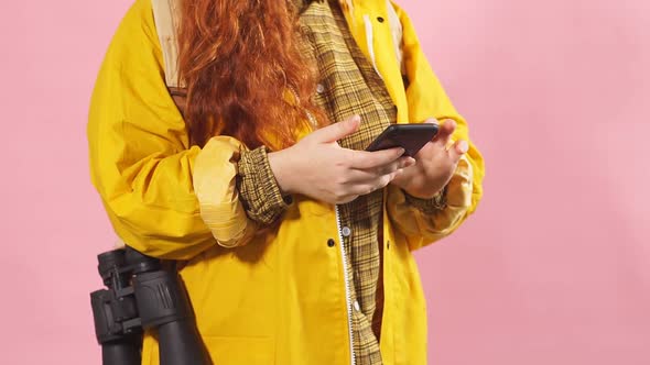 Portrait of a Red-haired Tourist Girl Using a Mobile Phone To View a Map.