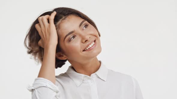 Young Beautiful Brunette East Asian Female in Shirt Looking Up Smiling in Astonishment on White