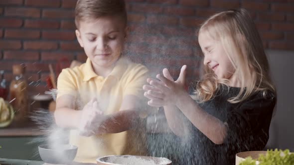 Boy and Girl Are Cooking and Clapping Their Hands in Flour