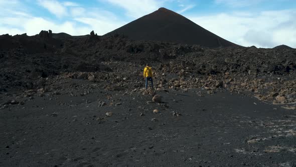 Man Traveler Walks Through the Lava Field Around Chinyero Volcano in the Teide National Park on the