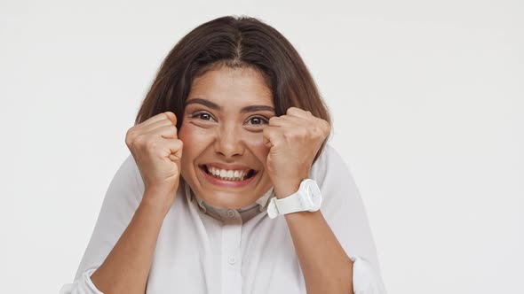 Young Beautiful Brunette East Asian Female in Shirt Actively Laughing Smiling in Amazement on White