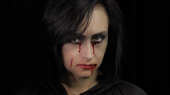 Vampire Halloween Makeup. Woman Portrait with Blood on Her Face.