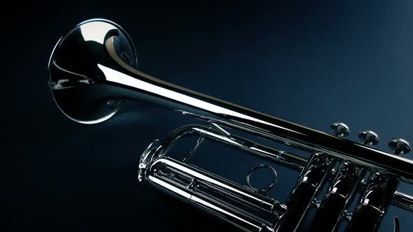 Shiny Silver Trumpet On Plain Surface Moving Shot