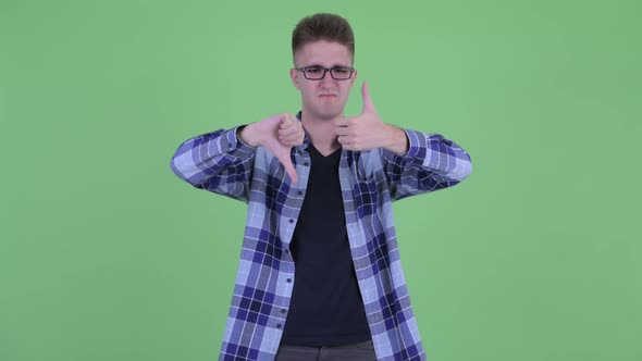 Confused Young Hipster Man Choosing Between Thumbs Up and Thumbs Down