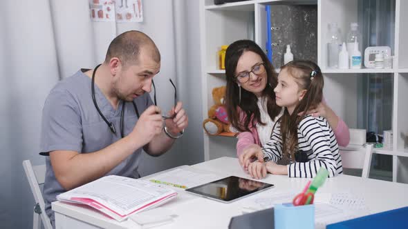 Friendly Doctor Talks with Patients Mom and Her Daughter