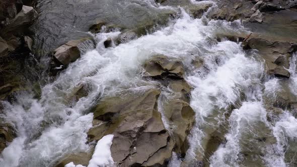 Rapid Flow of Water From a Mountain Creek and Stone Rapids with Snow. Waterfall Prut in the Winter.