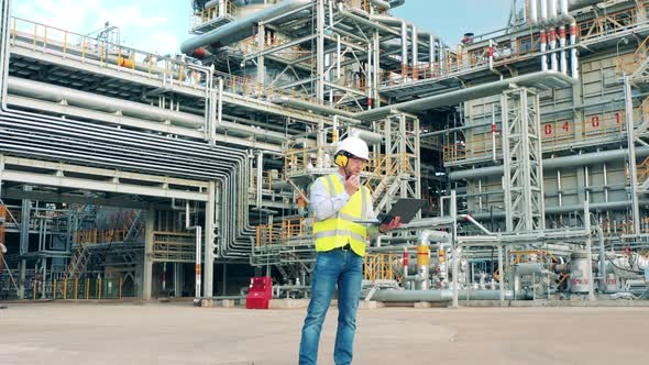 Refinery Engineer is Communicating Via Gadgets on the Plant Premises