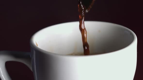 Coffee being poured in slow motion into a white cup