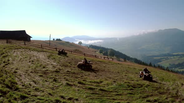 Three Friends Riding on Quad Bikes in Mountains