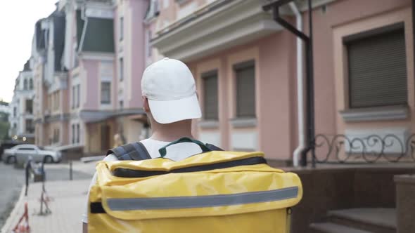 Delivery Man Courier Arrives at Residential Address To Deliver Food