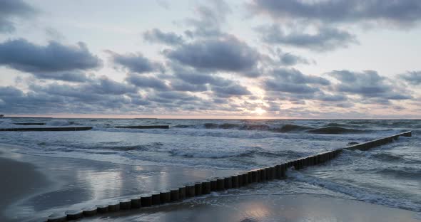 Breakwater of Larch Logs. Strengthening the Seashore To Keep the Sand on the Beach. Gorgeous Sunset